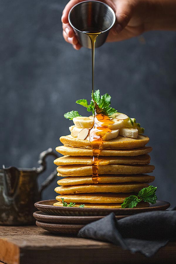 Maple-syrup-being-poured-over-pancakes